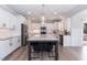 Bright kitchen boasts white cabinets, stainless appliances, gray island with seating, and wood-look floors at 76 Freewill Pl, Raleigh, NC 27603