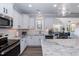 Bright kitchen featuring white cabinets, stainless appliances, light countertops, and a view to the dining room at 76 Freewill Pl, Raleigh, NC 27603
