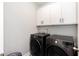 Convenient laundry area with modern, front-load washer and dryer, and above-cabinet storage at 76 Freewill Pl, Raleigh, NC 27603
