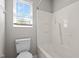 Bathroom including a tub with shower, commode, and window with blinds at 765 S Hollybrook Rd, Wendell, NC 27591