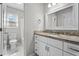 Bathroom with granite countertop, white cabinets, decorative mirror, and an open shower/bath at 765 S Hollybrook Rd, Wendell, NC 27591