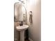 Modern powder room with pedestal sink, decorative mirror, and stylish fixtures at 80 Willow Green Dr, Clayton, NC 27527