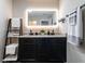 Bright bathroom with dual sinks, decorative ladder, and an illuminated mirror at 80 Willow Green Dr, Clayton, NC 27527