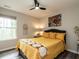 Cozy bedroom with a ceiling fan, window, and a bright yellow comforter with decorative pillows at 80 Willow Green Dr, Clayton, NC 27527