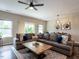 Living room features an area rug, large windows, ceiling fan, and comfortable sectional sofa at 80 Willow Green Dr, Clayton, NC 27527