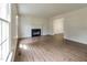Bright living room features hardwood floors, a fireplace, and natural light from a large window at 805 Penncross Dr, Raleigh, NC 27610