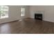Cozy living room with fireplace, hardwood floors, and natural light from two windows at 805 Penncross Dr, Raleigh, NC 27610