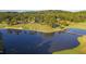 Aerial view of a golf course, lake with bridge, and surrounding trees, showcasing the community's natural beauty at 81502 Alexander, Chapel Hill, NC 27517