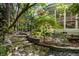 Beautiful backyard with stone steps, lush greenery, a screened porch, and manicured landscaping at 81502 Alexander, Chapel Hill, NC 27517