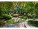 Picturesque backyard garden with stone pathways, lush greenery, and tranquil seating area at 81502 Alexander, Chapel Hill, NC 27517
