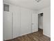 Bedroom features hardwood-style flooring, white closets, and fresh paint at 995 Shawtown Rd, Lillington, NC 27546