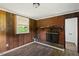 Living room with hardwood floors, a brick fireplace, and a window providing natural light and a cozy feel at 995 Shawtown Rd, Lillington, NC 27546