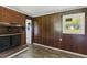 Living room with a brick fireplace, wood-paneled walls, and hardwood floors, creating a rustic ambiance at 995 Shawtown Rd, Lillington, NC 27546
