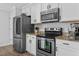 Modern kitchen with stainless steel appliances, granite countertops, and white cabinets offers a blend of style and functionality at 100 Stratford Lakes Dr # 361, Durham, NC 27713