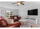 Comfortable living room featuring a leather sofa, TV, and large window offering natural light at 100 Stratford Lakes Dr # 361, Durham, NC 27713