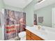 Well-lit bathroom with a decorative shower curtain and wood vanity at 104 Jj Dr, Benson, NC 27504