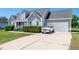 Charming two-story home with gray siding, an attached garage, and a well-maintained lawn at 104 Jj Dr, Benson, NC 27504