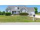 Charming home featuring manicured hedges, a gray exterior, and an attached garage at 104 Jj Dr, Benson, NC 27504