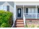 Inviting front porch with decorative black door and white railing at 104 Jj Dr, Benson, NC 27504