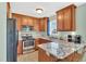 Modern kitchen with stainless steel appliances, granite countertops, and wood cabinets at 104 Jj Dr, Benson, NC 27504