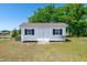 White outbuilding with black shutters offers additional storage or workspace in the backyard at 104 Jj Dr, Benson, NC 27504