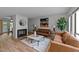 Bright living room with a decorative fireplace, two leather sofas and a stylish area rug at 109 Virginia Pl, Cary, NC 27513