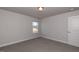 An empty bedroom with neutral paint, carpet, and a window allowing natural light at 111 High Hampton Way, Fuquay Varina, NC 27526