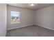 An empty bedroom showcasing carpet, a window with natural light, and neutral walls at 111 High Hampton Way, Fuquay Varina, NC 27526