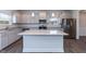 Modern kitchen boasts stainless appliances, granite countertops, and stylish gray cabinets at 111 High Hampton Way, Fuquay Varina, NC 27526
