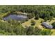Aerial view showcases the home, surrounded by lush greenery and a tranquil pond at 1131 Pulley Gordon Rd, Zebulon, NC 27597