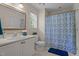 Bathroom with a white vanity, framed mirror, and a shower-tub combo with a patterned curtain at 1131 Pulley Gordon Rd, Zebulon, NC 27597