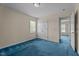 Bedroom with plush blue carpet, a window with blinds, and a closet across from the entrance at 1131 Pulley Gordon Rd, Zebulon, NC 27597