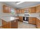 Well-lit kitchen featuring oak cabinets, a white countertop, and modern appliances at 1131 Pulley Gordon Rd, Zebulon, NC 27597