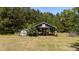 A large outbuilding and storage shed nestled amongst a dense forest of trees at 1131 Pulley Gordon Rd, Zebulon, NC 27597