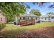 A well-kept backyard featuring a wooden deck, with lush greenery and partial shade from surrounding trees at 1208 W Murray Ave, Durham, NC 27704