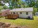 Home's backyard features wooden deck with ramp, level lawn, partial shade, and mature trees at 1208 W Murray Ave, Durham, NC 27704