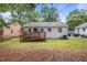 A well-maintained backyard featuring a wooden deck, surrounded by lush greenery and neighboring houses at 1208 W Murray Ave, Durham, NC 27704