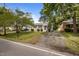 Exterior view of a charming one-story home with mature trees, lush lawn, and driveway at 1208 W Murray Ave, Durham, NC 27704
