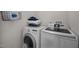An efficient laundry area featuring modern, white washer and dryer units with wire storage and neatly folded towels at 1208 W Murray Ave, Durham, NC 27704