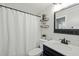 Cozy bathroom offers a shower with white curtain, dark wood vanity, framed mirror, and shelving at 1220 Sherbrooke Ct, Raleigh, NC 27612