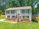 Charming split-level home featuring a vibrant yellow front door and well-maintained lawn at 1220 Sherbrooke Ct, Raleigh, NC 27612