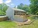 View of the home's backyard with a wooden deck, manicured lawn and brick trim work at 1220 Sherbrooke Ct, Raleigh, NC 27612