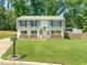 Split-level home with a well-manicured lawn, flower boxes, and wood fence at 1220 Sherbrooke Ct, Raleigh, NC 27612