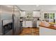Kitchen with stainless steel appliances, white cabinets, wood-look floors, and view to the outside deck at 1220 Sherbrooke Ct, Raleigh, NC 27612