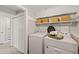 Well-organized laundry room with washer, dryer, and storage shelves at 1220 Sherbrooke Ct, Raleigh, NC 27612