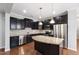 Modern kitchen with stainless steel appliances, granite countertops, dark cabinets, and hardwood floors at 1231 Silver Beach Way, Raleigh, NC 27606