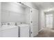 Convenient laundry room featuring white washer and dryer, plus overhead shelving at 1231 Silver Beach Way, Raleigh, NC 27606