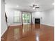 Bright living room with a fireplace, hardwood floors, access to a deck, and a ceiling fan at 1231 Silver Beach Way, Raleigh, NC 27606