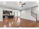 Open-concept living room with hardwood floors, neutral paint, ceiling fan, and stairs to the second floor at 1231 Silver Beach Way, Raleigh, NC 27606
