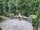Landscaped backyard patio featuring a stone fire pit, lovely stone wall, and surrounding greenery at 1309 Bartlett Cir, Hillsborough, NC 27278